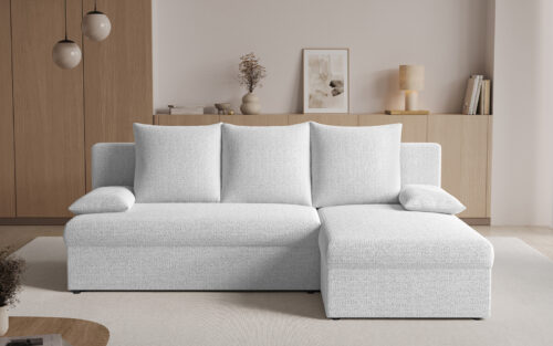 Light gray L-shaped sofa with chaise in a modern living room with beige walls and wooden cabinetry.